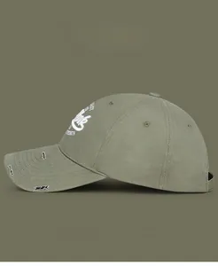 Detail of olive green baseball cap showing vintage distressed brim and white letter embroidery