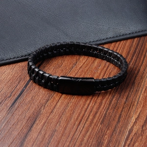 Detail of multi-strand braided black leather bracelet with a sleek black metal clasp