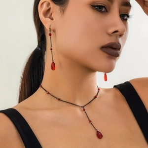 Detail of gothic choker and earrings set featuring red blood droplets on black chains