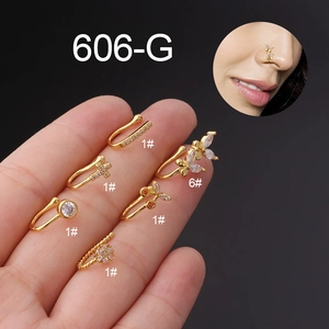 Detail of 6-piece gold butterfly nose clips set with zircon stones on black background