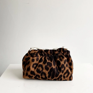 Close-up of leopard print velvet makeup bag with soft pleats and a white pearl fastener