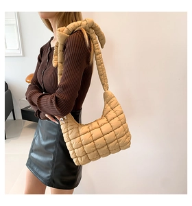 Detail of khaki quilted puffer shoulder bag with soft padded strap and checkered texture