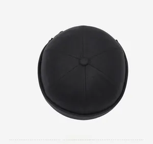 Top view of a black six-panel cotton docker cap showing fabric texture and crown button