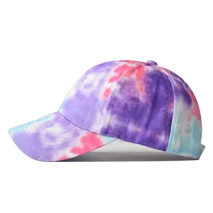 Detailed side view of tie-dye cotton baseball cap with purple and pink swirl patterns