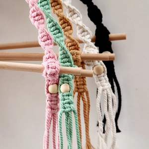 Detail of colorful hand-woven macrame hangers with natural wooden beads and soft tassels