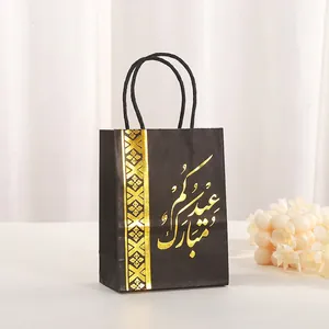 Close-up of black paper gift bag with gold foil Eid Mubarak Arabic calligraphy text