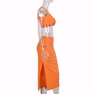 Detail view of the high waist side slit on the vibrant orange two-piece crop top set