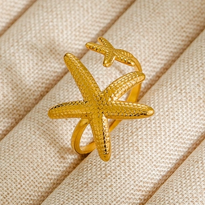 Anillo abierto bañado en oro con un lindo diseño de doble estrella de mar texturizada.
