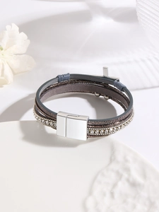 Detail view of multi-layer leather bracelet with cross charms and magnetic metal clasp