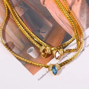 Detailed view of gold snake chains featuring marquise-cut colorful zircon gemstone pendants
