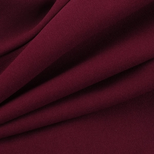 Texture détaillée du tissu mousseline bordeaux avec des plis doux et élégants