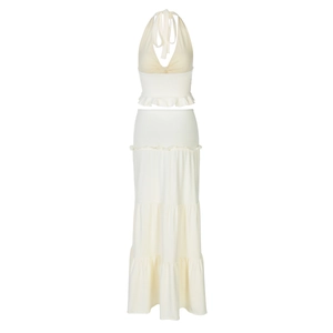 Flat lay of off-white two-piece set featuring a halter top and tiered ruffle maxi skirt