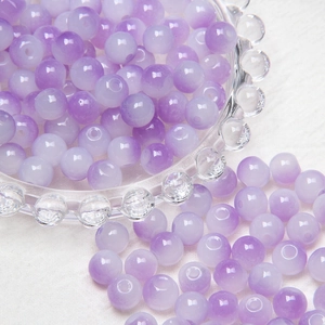 Macro detail of 8mm purple translucent glass beads with a smooth matte silk texture