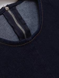 Detailed macro view of denim dress featuring metal zipper and contrast stitching