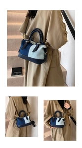 Detail of denim patchwork Boston bag with gold-tone hardware and contrast stitching