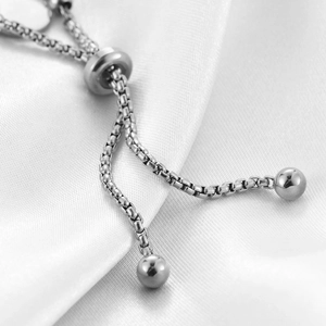 Macro detail of adjustable silver box chain with sliding bead and spherical ends