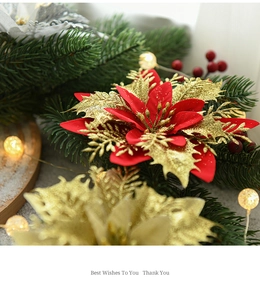 Detail of red and gold Christmas poinsettia with glitter petals and warm festive LED lights