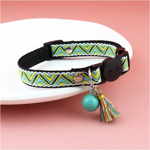 Detail of plaid cat collar with bell, tassel, and cat-shaped buckle on pink background