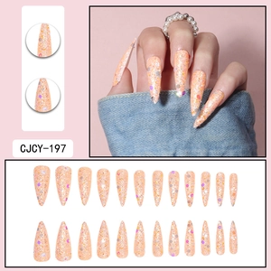 Detailed view of long stiletto press-on nails with pink-orange glitter and iridescent sequins