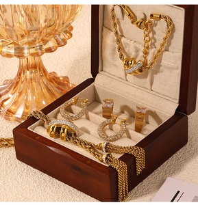 Macro shot of gold-plated twisted chain necklace and rhinestone rings on jewelry box