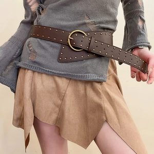 Detail of vintage wide leather belt with brass studs and large round metal buckle