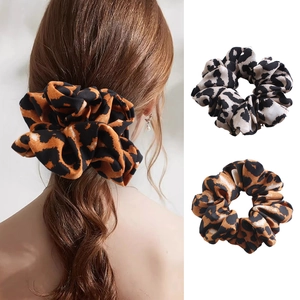 Detail of leopard print scrunchies in brown and beige colors with a model wearing a set