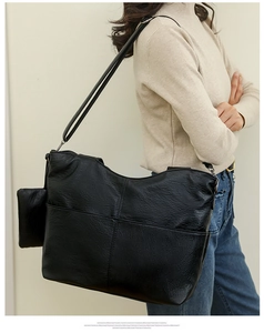 Detail of black faux leather tote with lychee texture and hanging mini zip pouch