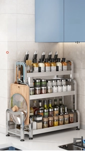 Three-tier stainless steel kitchen rack showing tiered storage for spice jars and tools