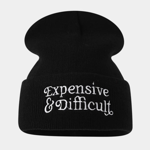 Close-up of high-quality black knit beanie featuring white Expensive & Difficult embroidery