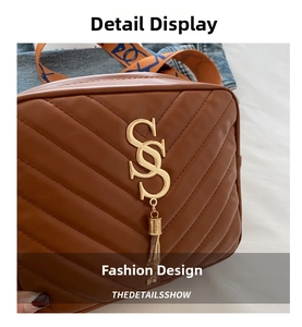 Close-up of caramel V-quilted leather bag with golden logo, tassel and woven strap