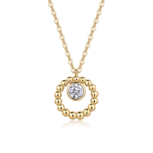 Close-up of golden teardrop pendant with central clear stone and beaded metal detailing