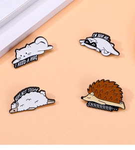 Set of four cute animal enamel pins including hedgehog and cat with funny sayings