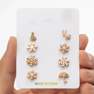 Close-up of stainless steel Christmas stud earrings featuring snowflake and elk designs