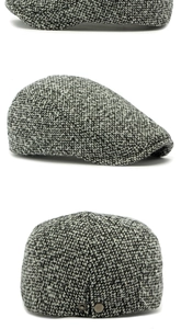 Macro shot of grey tweed flat cap showing textured fabric and metal back adjustment buckle