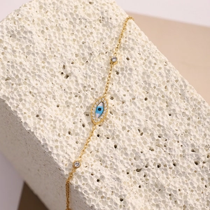 Detail of 18K gold plated chain bracelet with evil eye charm and clear cubic zirconia