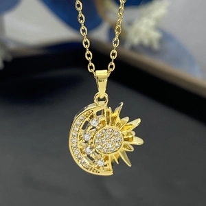 Macro shot of gold-plated sun and moon pendant with sparkling white zircon stones