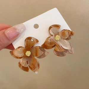 Macro shot of resin flower earrings with amber marble texture and gold core details