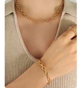 Macro detail of French vintage gold oval link necklace and bracelet jewelry set on model