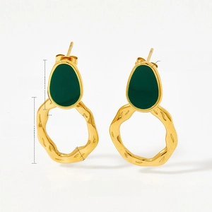 Détail de boucles d'oreilles vintage en émail avec anneaux irréguliers en acier doré