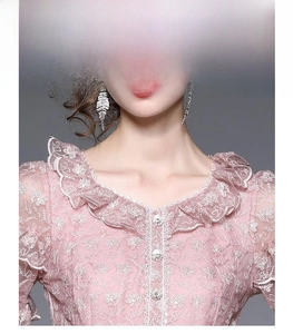 Détail de la robe en dentelle florale rose avec col à volants et boutons en strass