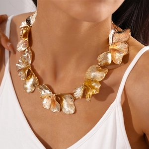 Close-up of gold-finish ginkgo leaf necklace with detailed vein textures on model