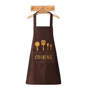 Brown waterproof kitchen apron with front pocket and yellow cooking prints on a wooden hanger