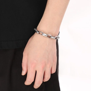 Close-up of polished silver industrial square link chain bracelet worn on a wrist