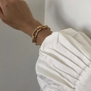 Close-up of a chunky 18k gold plated stainless steel chain bracelet on a model wrist