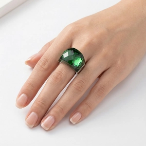 Close-up of oversized emerald green crystal ring with polished 18k gold plated band