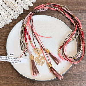Detail of vintage bohemian beaded necklace with heart pendants and leather tassels