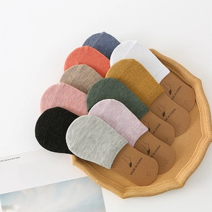 Macro shot of colorful cotton invisible socks arranged neatly on a wooden tray