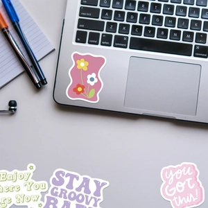 Detail of colorful aesthetic VSCO stickers on laptop with floral patterns and quotes