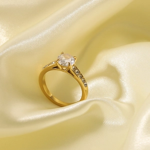 Classic four-prong 18k gold plated stainless steel ring with zircon on silk fabric