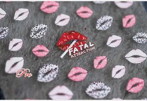 Macro shot of 5D nail stickers featuring red leopard lip patterns on a soft grey fur background